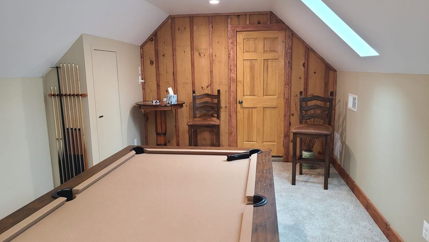 Finished bonus room with custom wood wall and pool table by Meekins