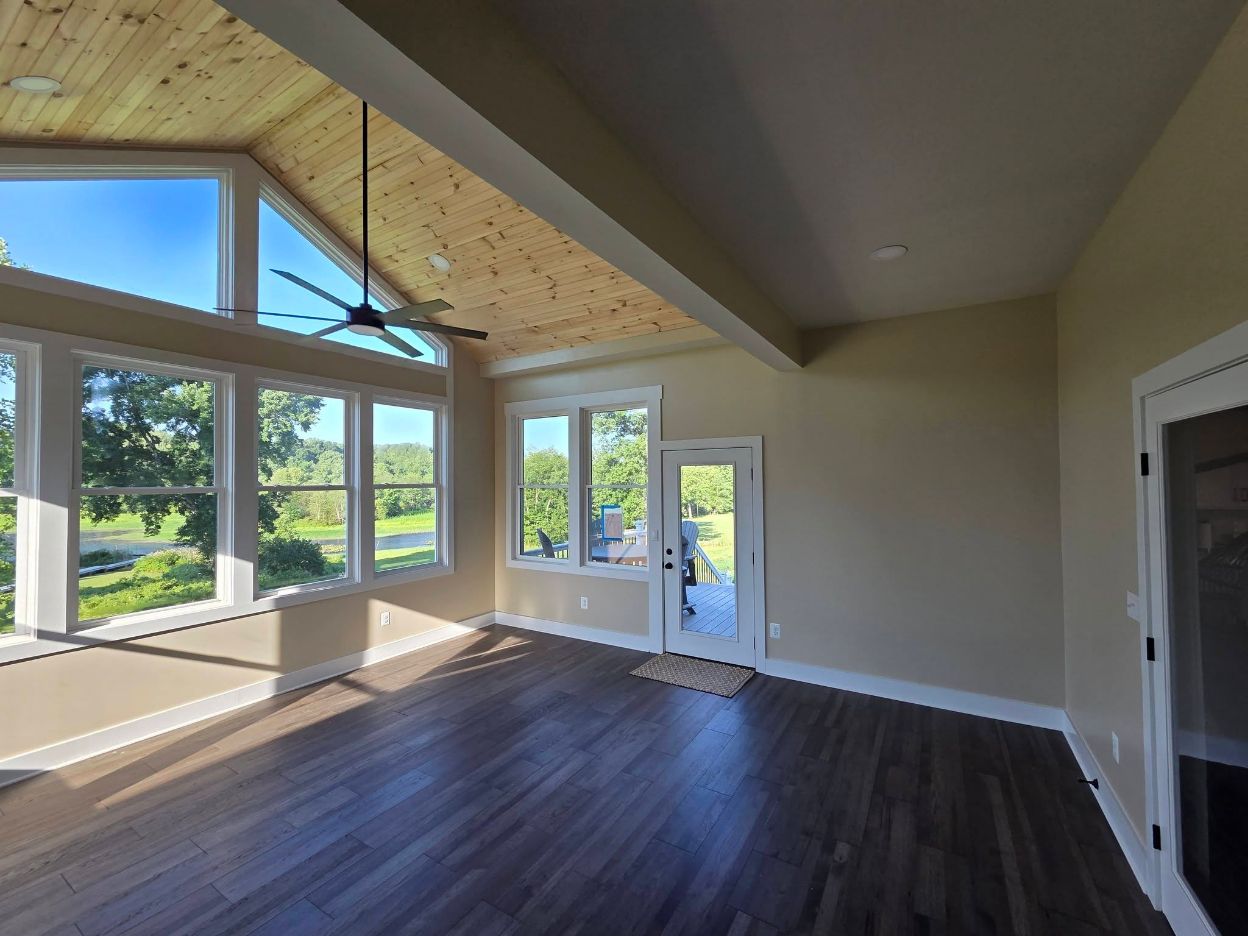 Finished Lake Anna addition by Meekins with large windows, wood ceiling, and dark flooring